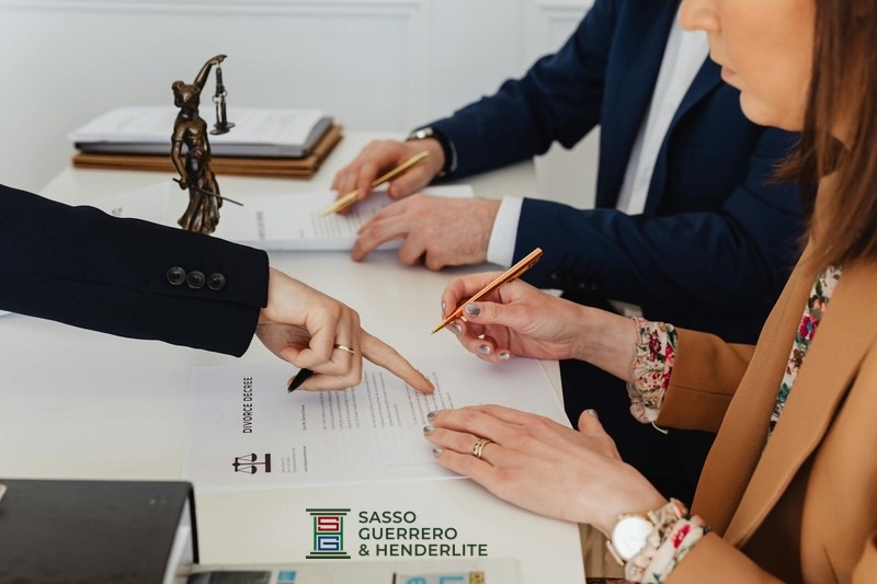 Couple signing divorce documents while receiving guidance from Sasso Guerrero & Henderlite for families in Fernandina Beach and Nassau County, Florida.